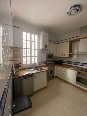 A kitchen with a dishwasher, washing machine, microwave, and a water heater. - Home Tendillas de Córdoba (Córdoba)