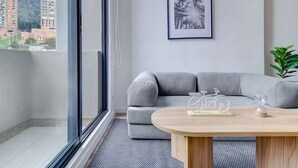 A modern living room with a grey sofa, a wooden coffee table, and a framed picture on the wall. - w* |  Stylish & Cozy Duplex Loft in Zona G (Bogotá)