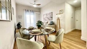 A dining area with a round table, chairs, and a ceiling fan. - House in City Garden 3 (Córdoba)