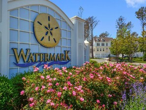 A building with a large sign reading 'WATERMARK' and a flower garden in front. - Modern 4BR House near Bethany Beach | Decks & Pool (Bethany Beach)