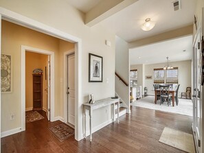 A spacious hallway with a wooden floor, a white console table, and a framed picture on the wall. - Modern 4BR House near Bethany Beach | Decks & Pool (Bethany Beach)