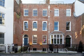 A multi-story brick building with a white facade, numbered doors, and a black metal fence. - Sleeps 5, 2 Bed Flat In The Lanes, Brighton (Brighton and Hove)
