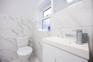 A bathroom with a toilet, a sink, and a window above the sink. - Sleeps 5, 2 Bed Flat In The Lanes, Brighton (Brighton and Hove)