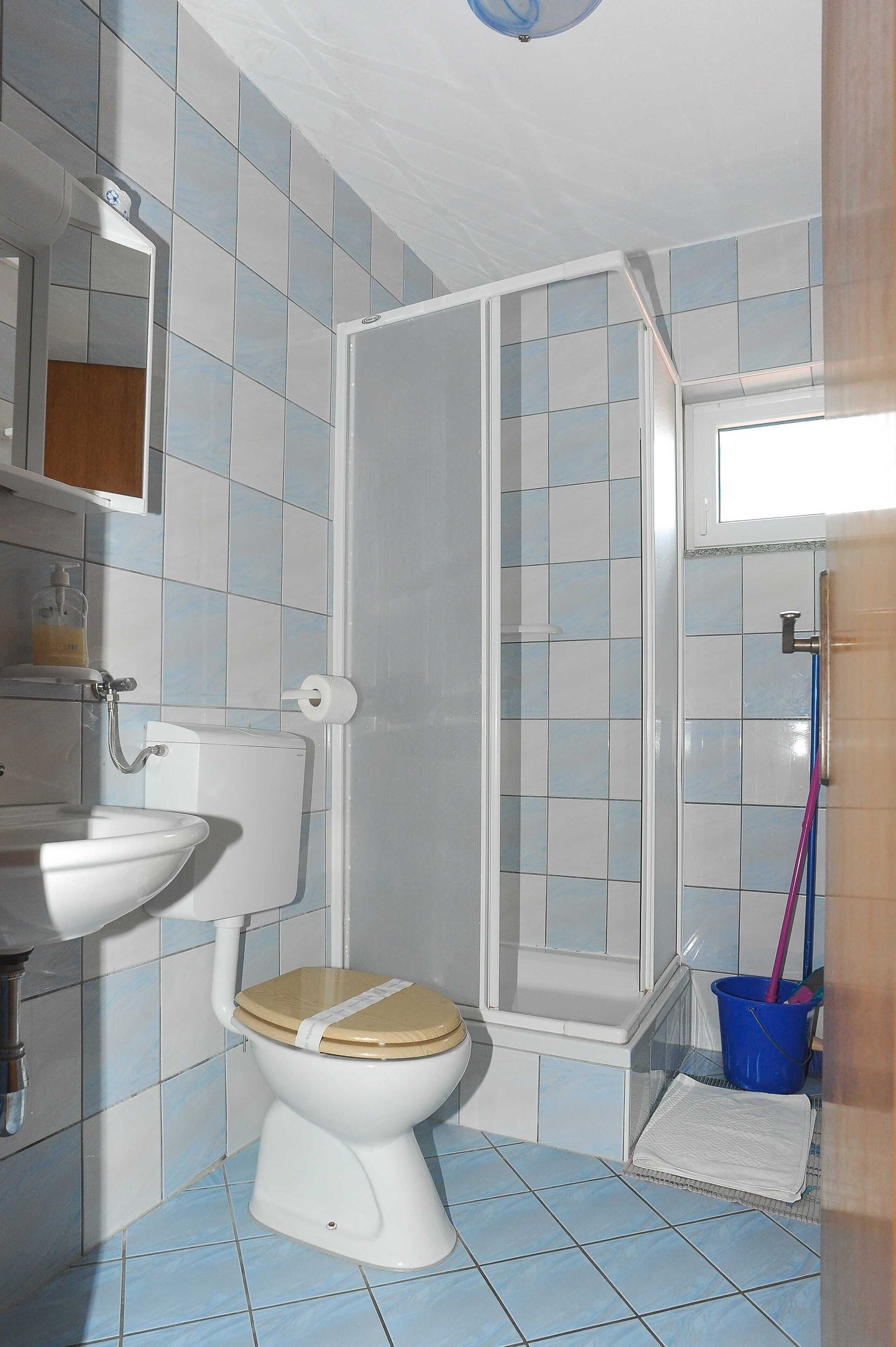 A bathroom with a toilet, sink, and shower area.