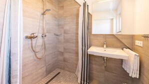 A modern bathroom with a walk-in shower, a sink, and a mirror. - Ferienresidenz Hinterzarten FEWO H9 (Hinterzarten)