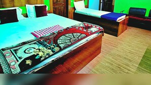 Una habitación con dos camas, armarios de madera y paredes verdes.