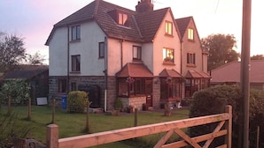 A two-story house with a garden, a wooden gate, and a chimney. - Dilston House (Whitby)