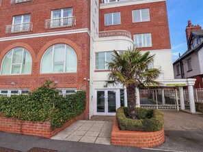 A red brick building with large arched windows and a palm tree in the center. - Beachcomber (Whitby)