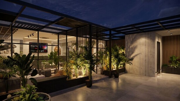 A modern indoor space with a glass partition, potted plants, and a seating area. - Liza Royale Hotel  (Chennai)