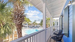 A balcony with a pool, palm trees, and a view of other buildings. - Bikes*Pool&Hottub*Walk2Beach (Santa Rosa Beach)