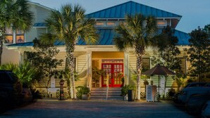 A hotel with a red entrance door, palm trees, and a blue roof. - Bikes*Pool&Hottub*Walk2Beach (Santa Rosa Beach)