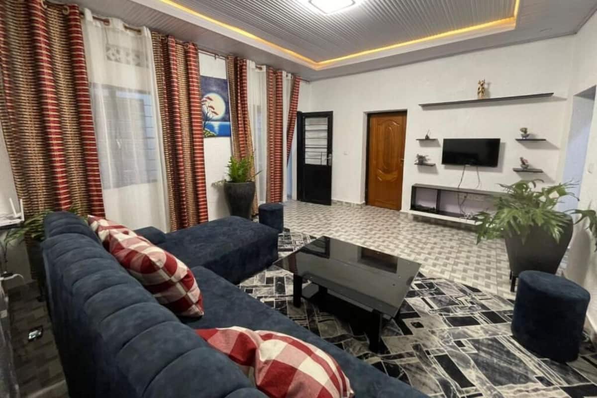 Una sala de estar moderna con sofá, mesa de centro y plantas en macetas.