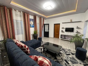 A modern living room with a sofa, coffee table, and potted plants.