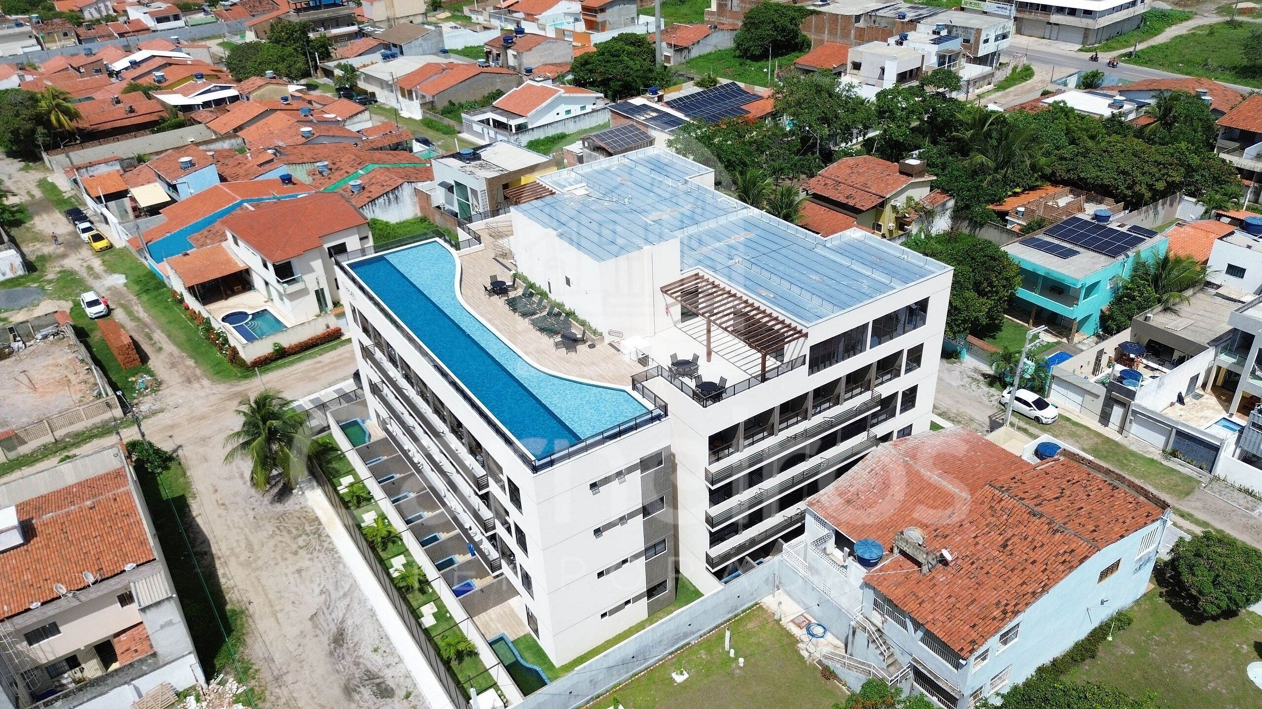 A multi-story building with a rooftop pool and solar panels.