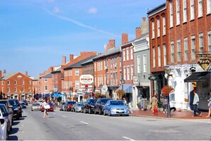 A street lined with brick buildings, a soda shop, and parked cars. - Moss Suite at The Hygge House (Newburyport)