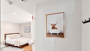 Ein Schlafzimmer mit Bett, Nachttisch und einem gerahmten Bild einer Jurte an der Wand.