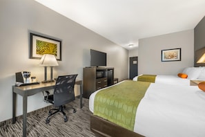 A hotel room with a bed, desk, chair, television, and artwork on the walls. - Best Western Plus Liberal Hotel & Suites (Liberal)