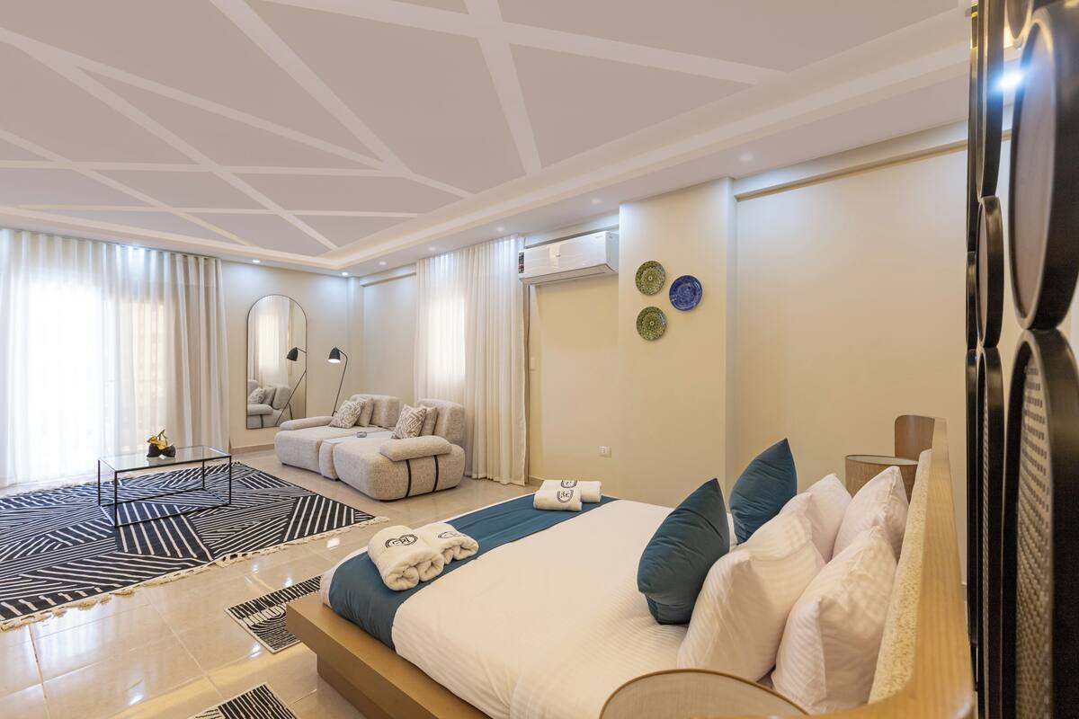 Ein modernes Hotelzimmer mit einem großen Bett, einer Couch, einem Couchtisch und einem Fernseher.