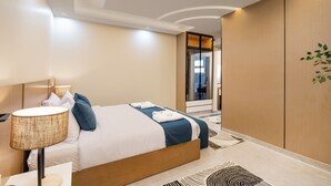 Ein modernes Hotelzimmer mit einem großen Bett, einer Nachttischlampe und Blick in die Hotellobby.