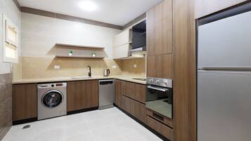A modern kitchen with built-in appliances, including a dishwasher, washing machine, oven, and a refrigerator.