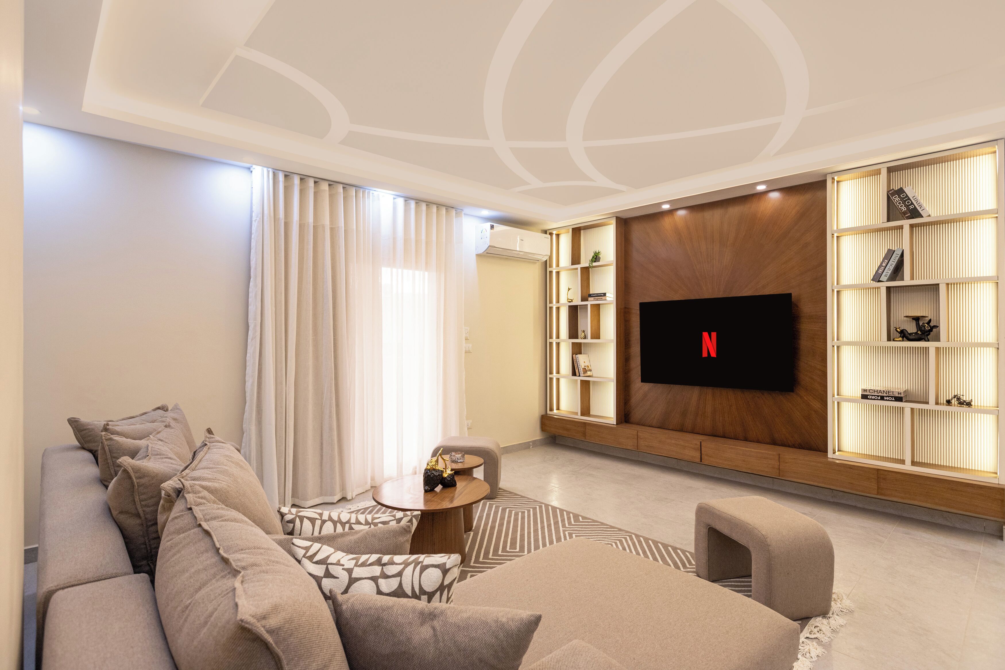 A modern living room with a sofa, a coffee table, and a TV mounted on the wall.