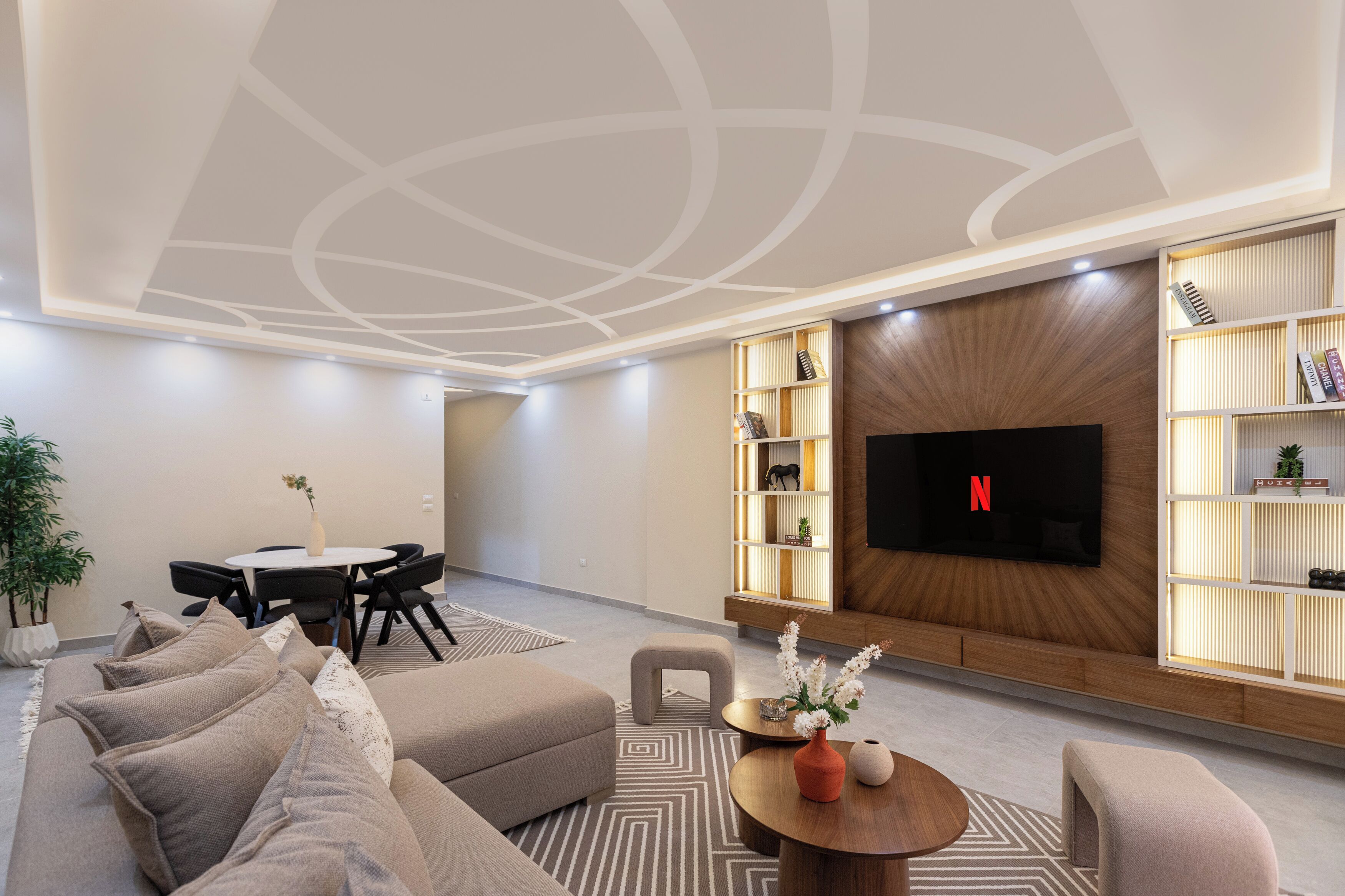 Una sala moderna con un sofá, una mesa de centro y un televisor montado en la pared.