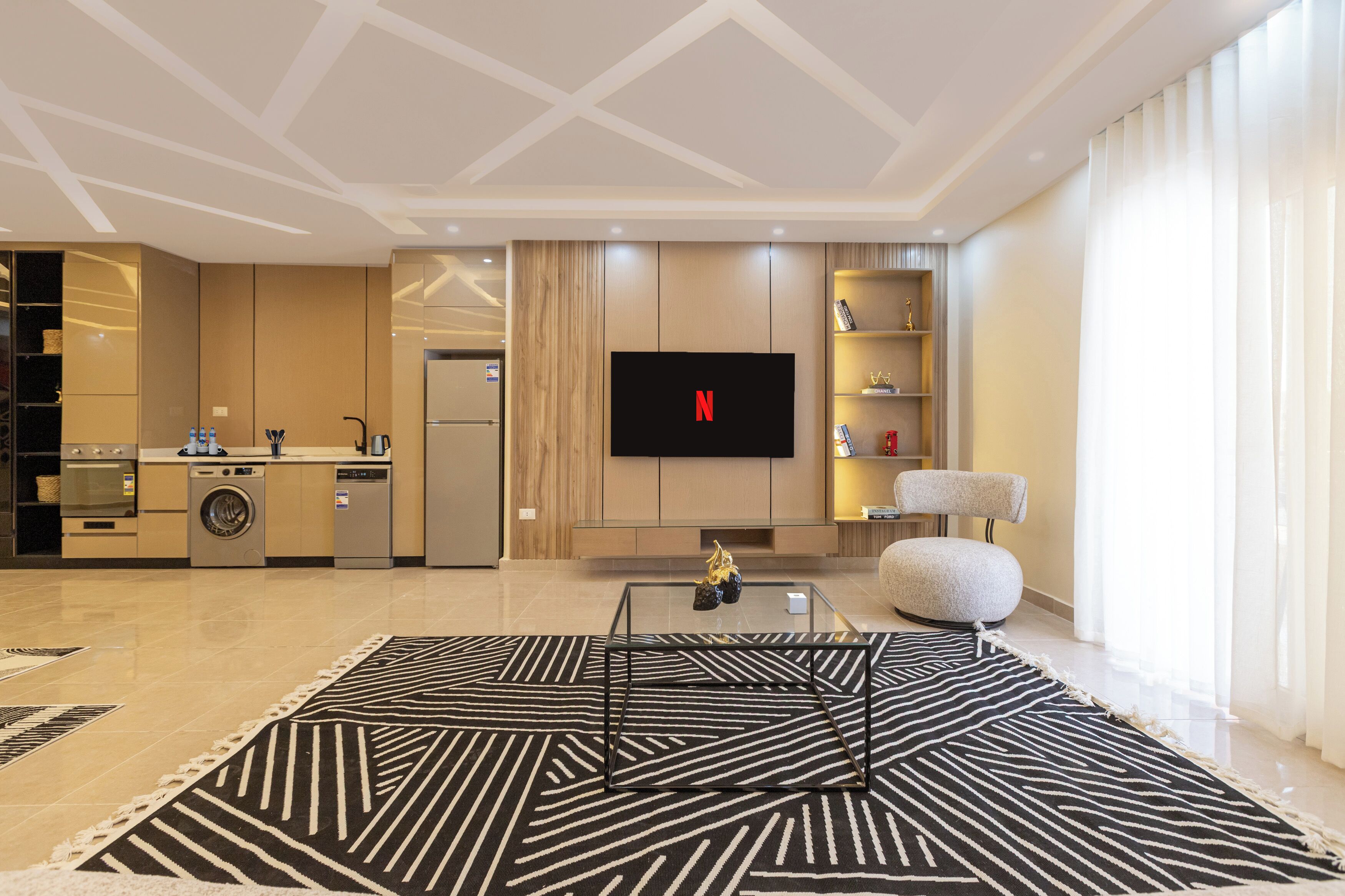 A modern living room with a flat-screen TV, a coffee table, and a sofa.