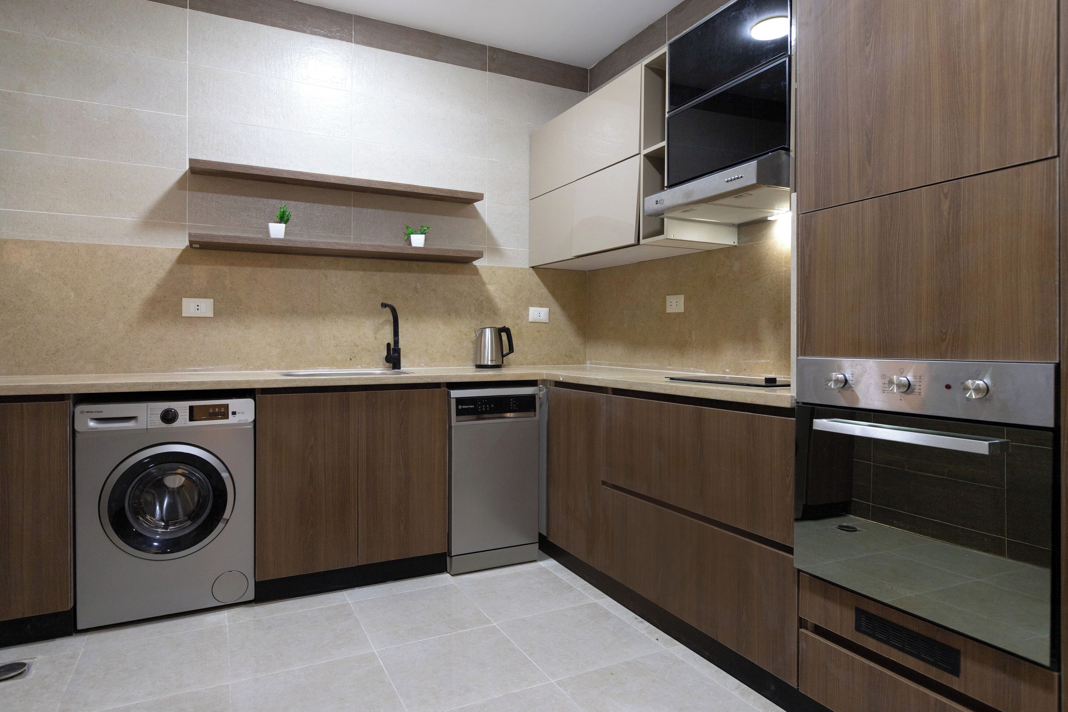 A modern kitchen with built-in appliances including a washing machine, dishwasher, and oven.