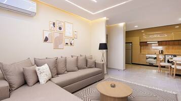 Departamento Deluxe, 2 habitaciones, balcón, vista a la ciudad | Área de sala de estar | Televisión LED de 65 pulgadas con canales vía satélite