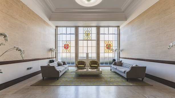 A spacious lobby with two sofas, a coffee table, and a large window with stained glass. - Stylish Historic Acton Apartment (London)
