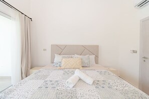 A neatly made bed with a floral-patterned bedspread and a rolled towel on it. - 3 Bedroom Villa in Estrella Dominicus w/ Pool (Dominicus)