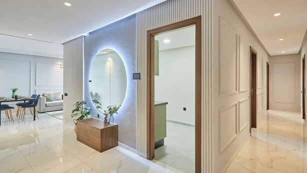 Een modern interieur met een receptiebalie, een eetgedeelte en een gang die naar andere kamers leidt.