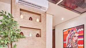 Un interior moderno con chimenea, una planta en maceta y un aire acondicionado de pared.
