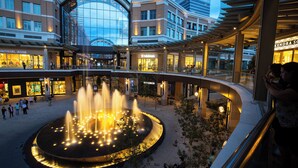 A shopping mall with a central fountain, stores like Michael Kors and Bonobos, and a curved walkway. - Siesta Inn (Salt Lake City)
