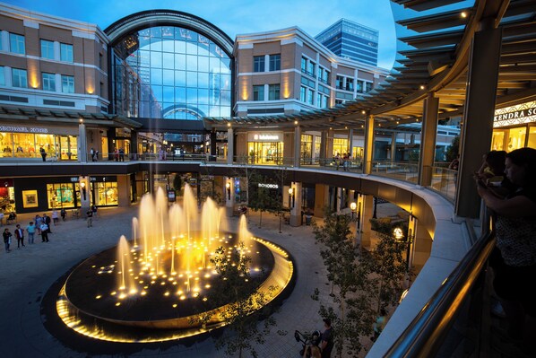 Ett köpcentrum med en central fontän, butiker som Michael Kors och Bonobos samt en böjd gångväg.