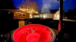 A heated outdoor pool with a wooden deck, a house with string lights, and a tree. - Gorgeous home in Vestervig with WiFi (Vestervig)