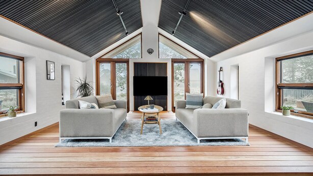 A spacious living room with two sofas, a coffee table, and a large window providing a view of the outdoors. - Gorgeous home in Vestervig with WiFi (Vestervig)