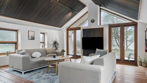 A modern living room with two sofas, a coffee table, and a large window offering a view of the outdoors. - Gorgeous home in Vestervig with WiFi (Vestervig)