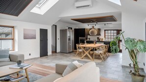 A spacious living area with a high ceiling, a dining table, and a kitchen in the background. - Gorgeous home in Vestervig with WiFi (Vestervig)