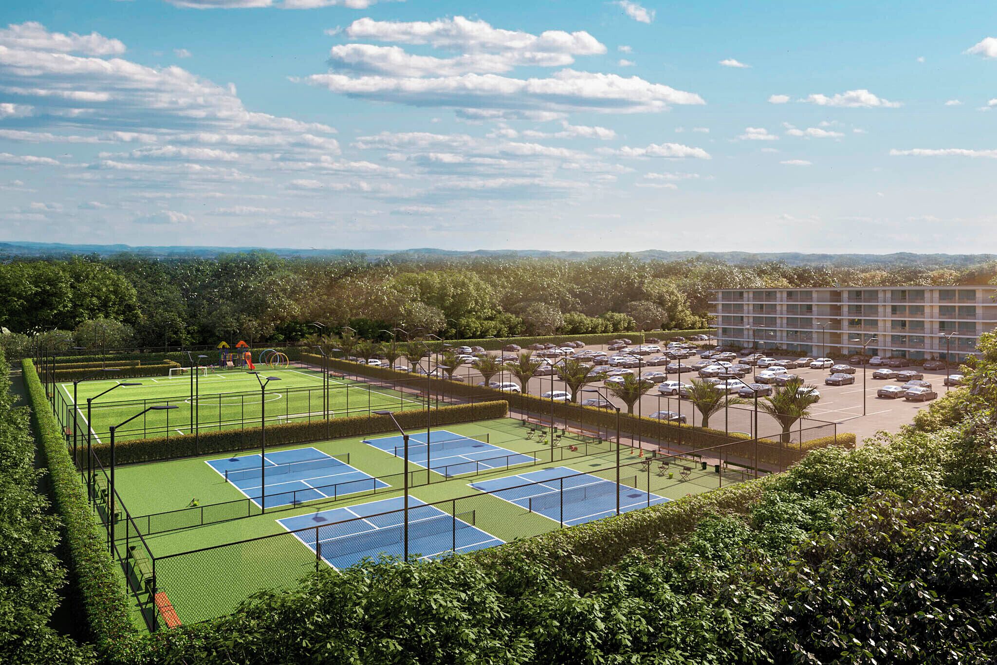 A tennis court surrounded by greenery, a parking lot, and a building in the background.