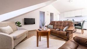 Een moderne woonkamer met een bank, een bijzettafeltje en een televisie.