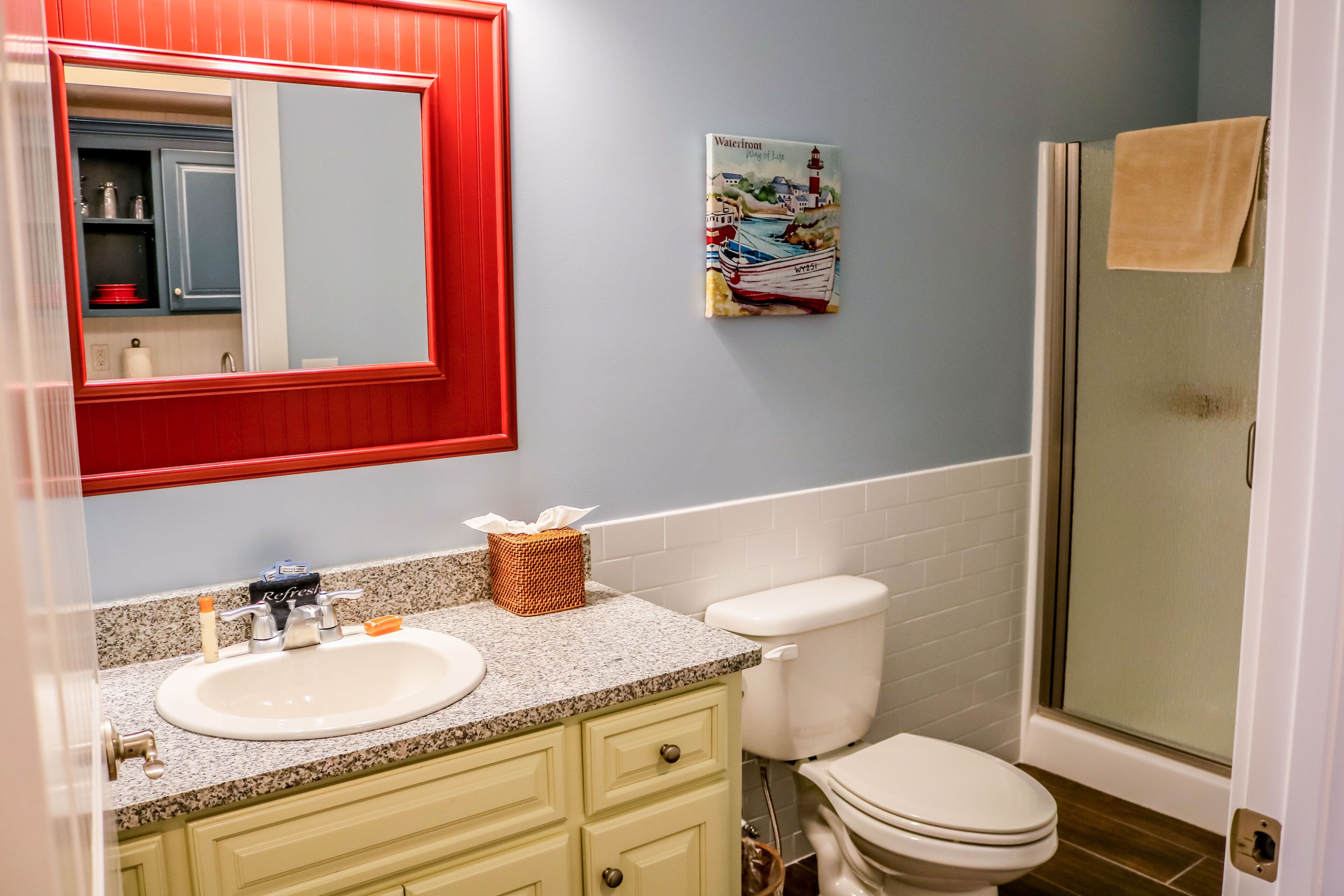 Ein Badezimmer mit Waschbecken, Spiegel, Toilette und Dusche.