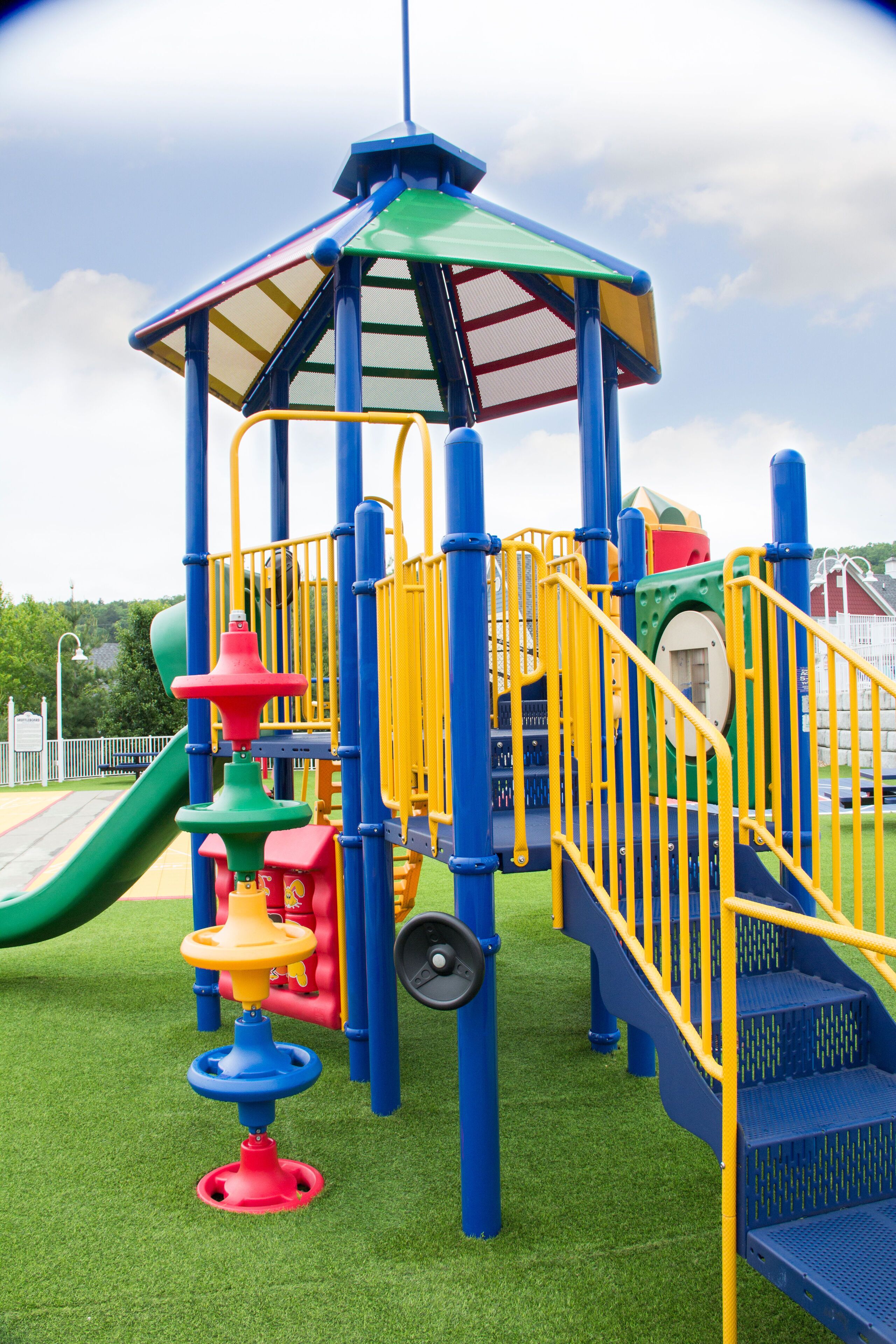 Une aire de jeux avec un toboggan, des structures d’escalade et un espace de jeux couvert.