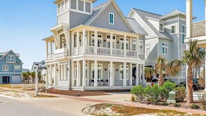 A large, multi-story house with a balcony and a covered porch. - Red White and Saguaro 246 DEW (Port Aransas)