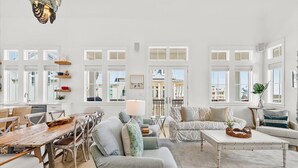 A spacious living room with a wooden dining table, grey sofas, and a white coffee table. - Red White and Saguaro 246 DEW (Port Aransas)
