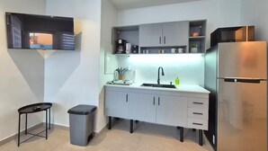 Una cocina moderna con horno empotrado, refrigerador de acero inoxidable y una zona de lavamanos compacta.