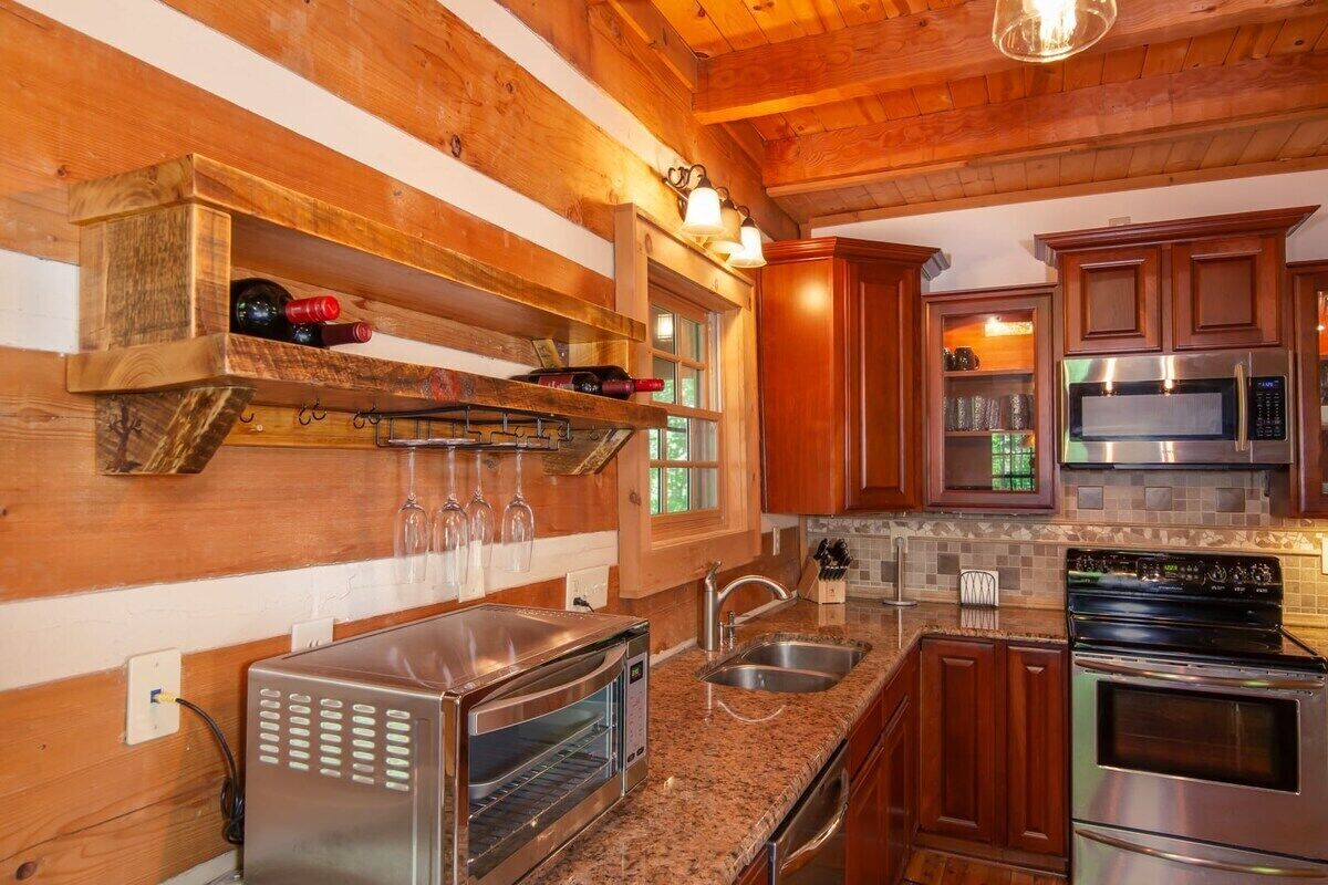 A kitchen with wooden walls, a built-in oven, a microwave, and a toaster.