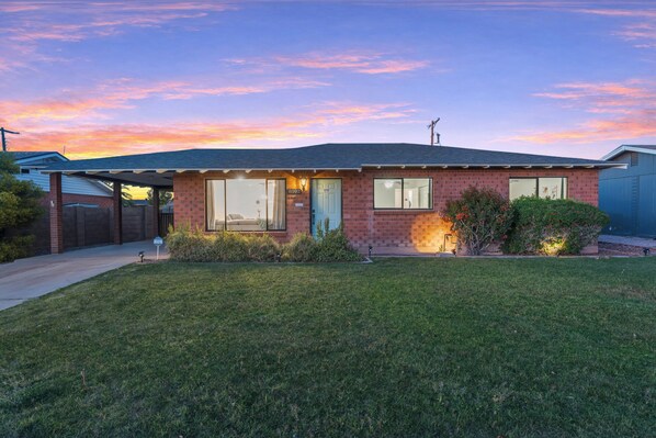 A single-story brick house with a front porch, a garage, and a well-maintained lawn. - OLD TOWN OASIS 4-BEDROOM, 2-BATHROOM/HEATED POOL/GAME ROOM/SLEEPS 11 (Scottsdale)