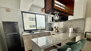 Eine moderne Küche mit Granitarbeitsplatte, integriertem Backofen und Fenster mit Blick auf die Stadt.