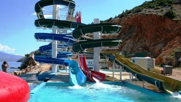 En vandpark med flere vandrutsjebaner og en swimmingpool.